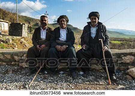 Stock Photograph - "Kurdish men sitting on a wall, Ahmed Awa, Iraqi Kurdistan, Iraq, Asia". Fotosearch