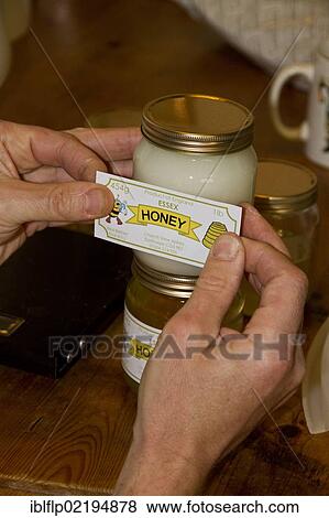 Labelling up a pot of borage honey View Large Photo Image Stock Photo - Labelling up a pot of borage honey. Fotosearch