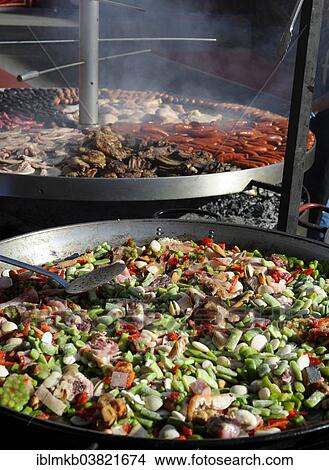 Picture - "Large pan containing ingredients for the paella in front of a giant barbecue at the annual All Saints Market in Cocentaina, Alicante province, Spain, Europe". Fotosearch