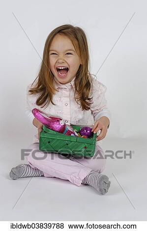 Laughing girl holding an Easter basket with a chocolate Easter bunny View Large Photo Image Stock Photo - Laughing girl holding an Easter basket with a chocolate Easter bunny. Fotosearch