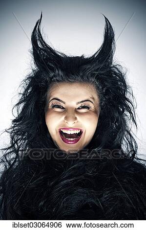 Stock Photograph - "Laughing young woman dressed as a devil with horns, Austria, Europe". Fotosearch