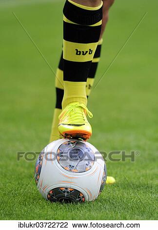 Stock Image - "Legs of a BVB player with an Adidas Torfabrik league ball, Dortmund, Ruhr district, North Rhine-Westphalia, Germany, Europe". Fotosearch