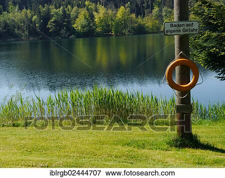 "Lifebuoy and sign """"Baden auf eigene Gefahr"""", German for """"swimming at your own risk"""", Degersee lake, Baden-Wuerttemberg, Germany, Europe" View Large Photo Image Stock Photo - "Lifebuoy and sign """"Baden auf eigene Gefahr"""", German for """"swimming at your own risk"""", Degersee lake, Baden-Wuerttemberg, Germany, Europe". Fotosearch