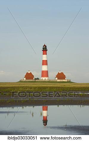 Stock Image - "Lighthouse and its reflection in the mudflats, Westerheversand, Westerhever, Eiderstedt, North Frisia, Schleswig-Holstein, Germany, Europe". Fotosearch