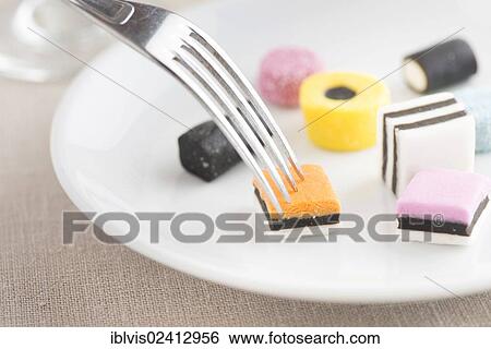 Liquorice candy served on a plate, fork View Large Photo Image Stock Photograph - Liquorice candy served on a plate, fork. Fotosearch