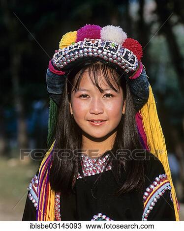 Stock Image - "Lisu girl wearing a colourful headdress and the traditional costume of the mountain people, portrait, Mae Sai, Chiang Rai Province, Northern Thailand, Thailand, Asia". Fotosearch