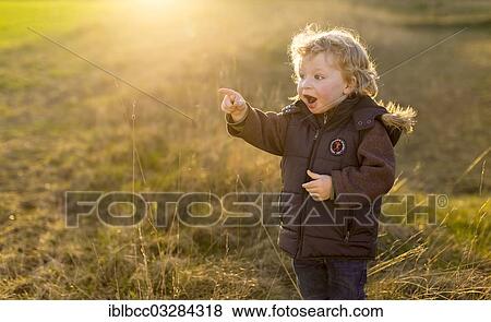 "Little boy, 2 years, standing on a meadow at sunset, pointing forward in amazement, Germany, Europe" View Large Photo Image Stock Photo - "Little boy, 2 years, standing on a meadow at sunset, pointing forward in amazement, Germany, Europe". Fotosearch