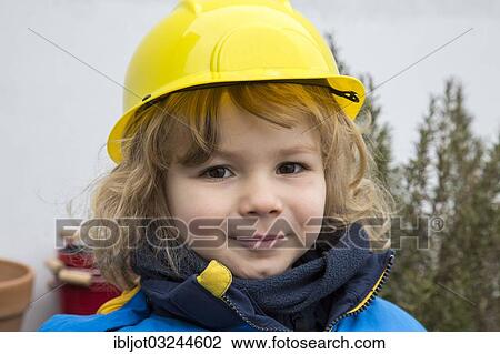 Stock Image - "Little boy, 3 years, with toy hard hat". Fotosearch