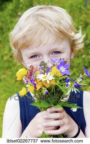 Little boy holding a bouquet of field flowers View Large Photo Image Stock Photo - Little boy holding a bouquet of field flowers. Fotosearch