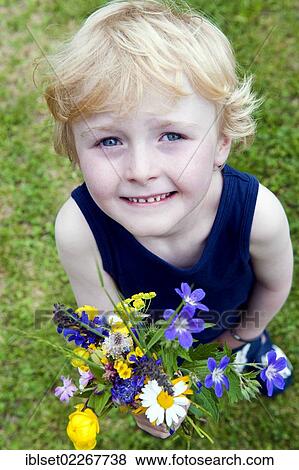 Stock Photo - Little boy holding a bouquet of field flowers. Fotosearch