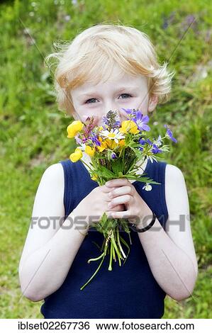 Little boy holding a bouquet of field flowers View Large Photo Image Stock Photograph - Little boy holding a bouquet of field flowers. Fotosearch