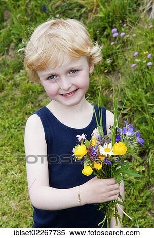 Stock Photography - Little boy holding a bouquet of field flowers. Fotosearch