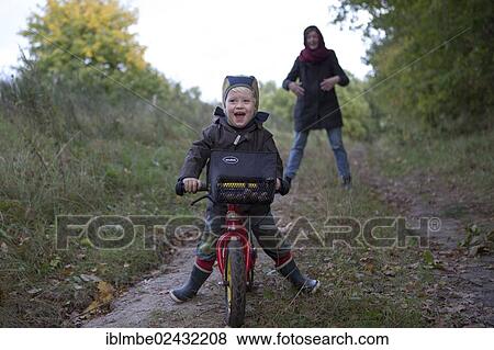 "Little boy is riding his bicycle down a forest path, laughing, Brandenburg, Germany, Europe" View Large Photo Image Stock Photo - "Little boy is riding his bicycle down a forest path, laughing, Brandenburg, Germany, Europe". Fotosearch