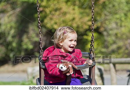 Picture - "Little girl laughing on a swing, Wuerzburg, Bavaria, Germany, Europe". Fotosearch