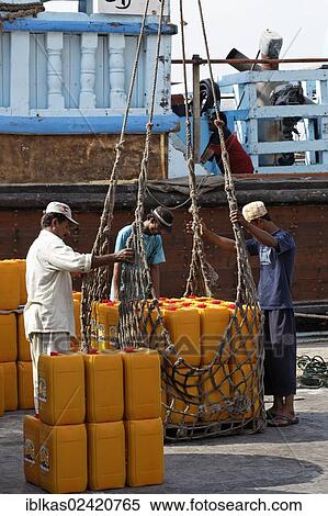 Loading cargo on an old wooden cargo ship, dhow or dau on Dubai Creek, Dubai, United Arab Emirates, Middle East, Asia View Large Photo Image Stock Photography - Loading cargo on an old wooden cargo ship, dhow or dau on Dubai Creek, Dubai, United Arab Emirates, Middle East, Asia. Fotosearch