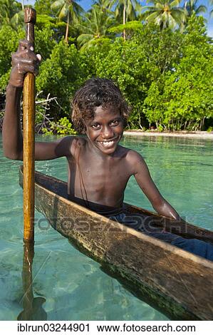 Stock Image - "Local boy in a canoe in the Marovo Lagoon, Marovo Lagoon, Western Province, Solomon Islands, Oceania". Fotosearch