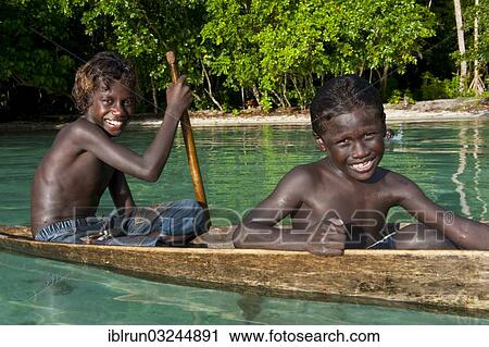 "Local boys in a canoe in the Marovo Lagoon, Solomon Islands, Oceania" View Large Photo Image Stock Image - "Local boys in a canoe in the Marovo Lagoon, Solomon Islands, Oceania". Fotosearch
