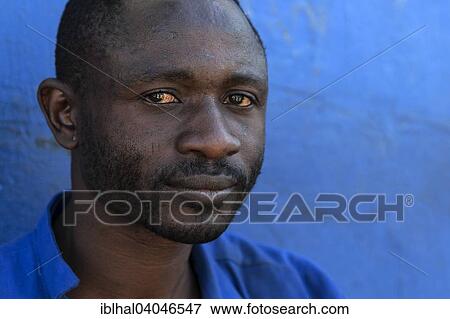 Stock Photo - "Local man against a blue wall, portrait, Swakopmund, Namibia, Africa". Fotosearch