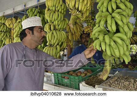 "Local man checking bananas on a stall, Salalah, Dhofar Region, Orient, Oman, Asia" View Large Photo Image Stock Photo - "Local man checking bananas on a stall, Salalah, Dhofar Region, Orient, Oman, Asia". Fotosearch
