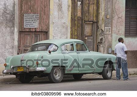 "Local man standing next to a classic car, Havana, Cuba, North America" View Large Photo Image Stock Photograph - "Local man standing next to a classic car, Havana, Cuba, North America". Fotosearch
