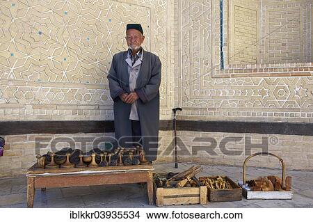 "Local man with bread stamps in front of the Kalon Mosque, Bukhara, Uzbekistan, Asia" View Large Photo Image Picture - "Local man with bread stamps in front of the Kalon Mosque, Bukhara, Uzbekistan, Asia". Fotosearch