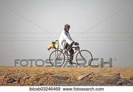 "Local resident riding a bicycle at Maga Dam, Maga Dam, Far North, Cameroon, Africa" View Large Photo Image Stock Photo - "Local resident riding a bicycle at Maga Dam, Maga Dam, Far North, Cameroon, Africa". Fotosearch