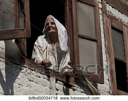 Stock Photo - "Local woman looking out of her window, Srinagar, Jammu and Kashmir, India, Asia". Fotosearch