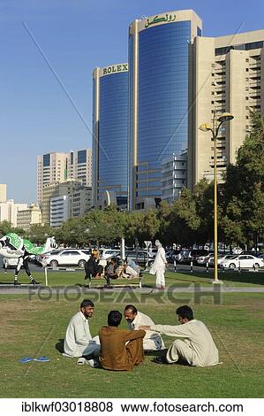"Locals in a park in front of the Rolex Towers, Daira, Dubai, Emirate of Dubai, United Arab Emirates, Asia" View Large Photo Image Stock Photo - "Locals in a park in front of the Rolex Towers, Daira, Dubai, Emirate of Dubai, United Arab Emirates, Asia". Fotosearch