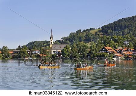 "Locals wearing traditional costumes in decorated wooden Platte boats, the church of St. Sixtus at the back, Alt-Schlierseer-Kirchtag festival, Schliersee, Upper Bavaria, Bavaria, Germany, Europe" View Large Photo Image Stock Image - "Locals wearing traditional costumes in decorated wooden Platte boats, the church of St. Sixtus at the back, Alt-Schlierseer-Kirchtag festival, Schliersee, Upper Bavaria, Bavaria, Germany, Europe". Fotosearch
