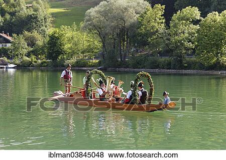 Stock Photo - "Locals wearing traditional costumes in a decorated wooden Platte boat, Alt-Schlierseer-Kirchtag festival, Schliersee, Upper Bavaria, Bavaria, Germany, Europe". Fotosearch