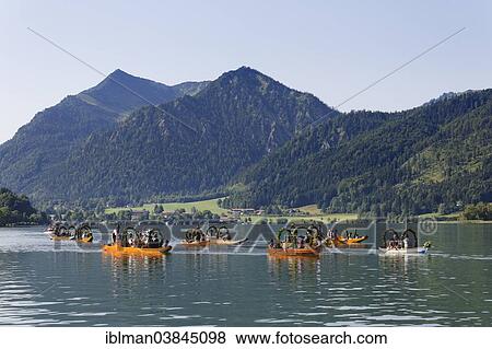 "Locals wearing traditional costumes in decorated wooden Platte boats, Brecherspitz mountain at the back, Alt-Schlierseer-Kirchtag festival, Schliersee, Upper Bavaria, Bavaria, Germany, Europe" View Large Photo Image Stock Photo - "Locals wearing traditional costumes in decorated wooden Platte boats, Brecherspitz mountain at the back, Alt-Schlierseer-Kirchtag festival, Schliersee, Upper Bavaria, Bavaria, Germany, Europe". Fotosearch