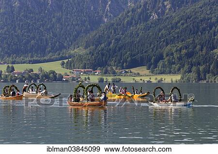 Stock Photo - "Locals wearing traditional costumes in decorated wooden Platte boats, Alt-Schlierseer-Kirchtag festival, Schliersee, Upper Bavaria, Bavaria, Germany, Europe". Fotosearch