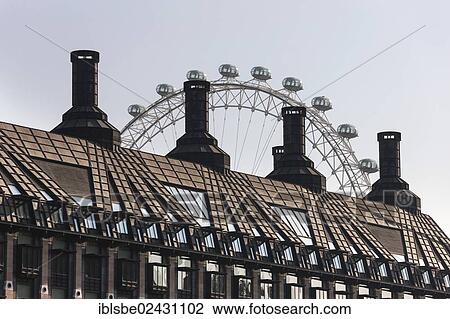 Stock Image - "London Eye behind the roof of the Portcullis House, Westminster, London, England, United Kingdom, Europe". Fotosearch