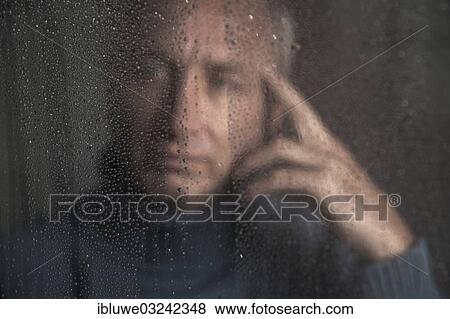 "Lonely man sitting behind a window covered in rain drops, Mannheim, Baden-Wurttemberg, Germany, Europe" View Large Photo Image Stock Photo - "Lonely man sitting behind a window covered in rain drops, Mannheim, Baden-Wurttemberg, Germany, Europe". Fotosearch