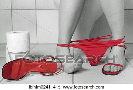 Stock Photography - Lower leg of a young woman sitting on the toilet in black and white with red thong panties and red strap shoes. Fotosearch