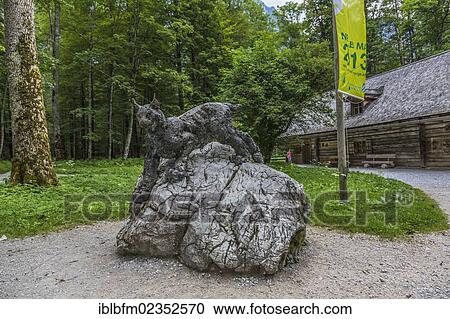 Stock Image - "Lynx sculpture, forest and trail at the Pilgrimage church of St. Bartholomew, Lake Koenigssee, Berchtesgaden, Berchtesgadener Land, Bavaria, Germany, Europe". Fotosearch