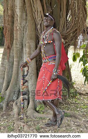 "Maasai warrior wearing traditional dress and standing in a typical pose on one leg, near Enkutoto, Masai Mara, Rift Valley Province, Kenya, Africa" View Large Photo Image Stock Image - "Maasai warrior wearing traditional dress and standing in a typical pose on one leg, near Enkutoto, Masai Mara, Rift Valley Province, Kenya, Africa". Fotosearch
