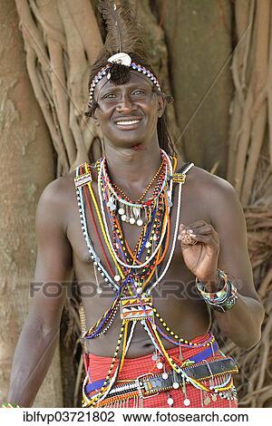 Stock Image - "Maasai warrior wearing traditional dress, near Enkutoto, Masai Mara, Rift Valley Province, Kenya, Africa". Fotosearch