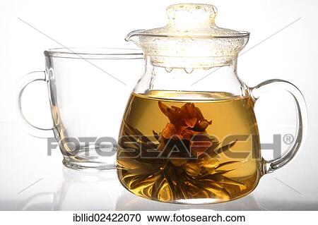 Stock Image - Magic Cherry, blooming tea, a dried flower unfolding in hot water. Fotosearch