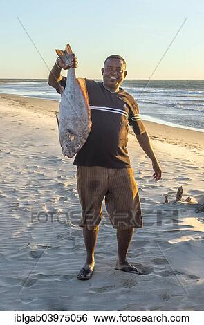 Stock Photograph - "Malagasy fisherman showing his catch, Morondava, Toliara province, Madagascar, Africa". Fotosearch