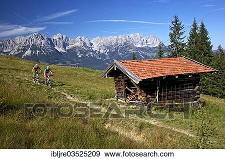 "Male and female mountain bikers on a singletrack in front of a hay barn, Kirchberg, Tyrol, Austria, Europe" View Large Photo Image Stock Photo - "Male and female mountain bikers on a singletrack in front of a hay barn, Kirchberg, Tyrol, Austria, Europe". Fotosearch