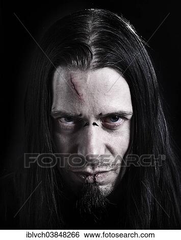 Stock Photograph - "Man, 30-35, with a scar on his forehead, piercings and long black hair". Fotosearch