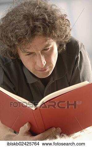 "Man, 30-40, reading a red book" View Large Photo Image Picture - "Man, 30-40, reading a red book". Fotosearch