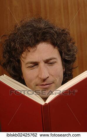 "Man, 30-40, reading a red book" View Large Photo Image Stock Image - "Man, 30-40, reading a red book". Fotosearch