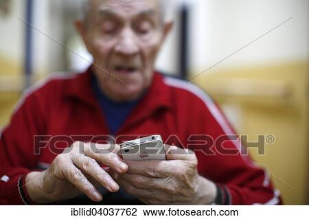 "Man, 87 years, holding a mobile phone, in a nursing home" View Large Photo Image Stock Image - "Man, 87 years, holding a mobile phone, in a nursing home". Fotosearch
