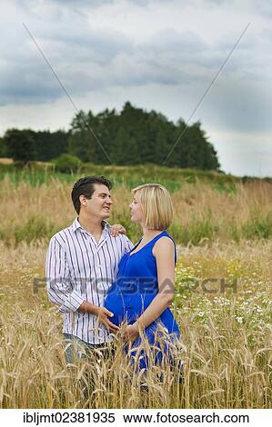 Man and a pregnant woman embracing in a field View Large Photo Image Stock Photography - Man and a pregnant woman embracing in a field. Fotosearch