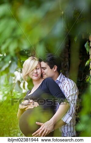 Man and a pregnant woman holding their hands on her belly View Large Photo Image Picture - Man and a pregnant woman holding their hands on her belly. Fotosearch