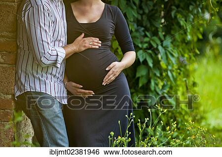 Man and a pregnant woman holding their hands on her belly View Large Photo Image Stock Photograph - Man and a pregnant woman holding their hands on her belly. Fotosearch