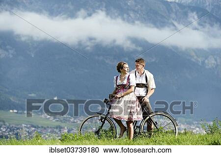 "Man and a woman wearing traditional costume with an old bicycle within a natural landscape, Aldrans, Tyrol, Austria, Europe" View Large Photo Image Stock Image - "Man and a woman wearing traditional costume with an old bicycle within a natural landscape, Aldrans, Tyrol, Austria, Europe". Fotosearch