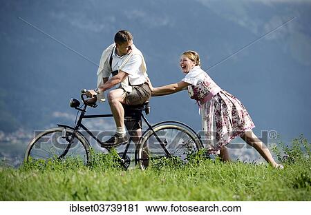 "Man and a woman wearing traditional costume with an old bicycle within a natural landscape, Aldrans, Tyrol, Austria, Europe" View Large Photo Image Stock Image - "Man and a woman wearing traditional costume with an old bicycle within a natural landscape, Aldrans, Tyrol, Austria, Europe". Fotosearch
